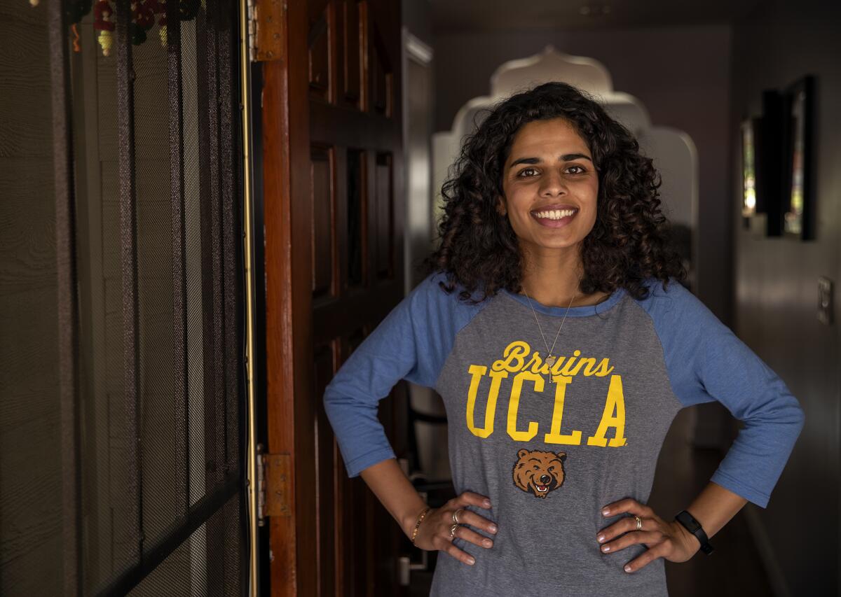 A woman wearing a UCLA shirt smiles.