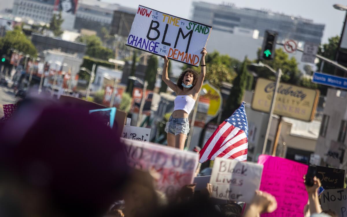 Nicholle Navarro holds a Black Lives Matter sign at a march through West Hollywood on June 3.