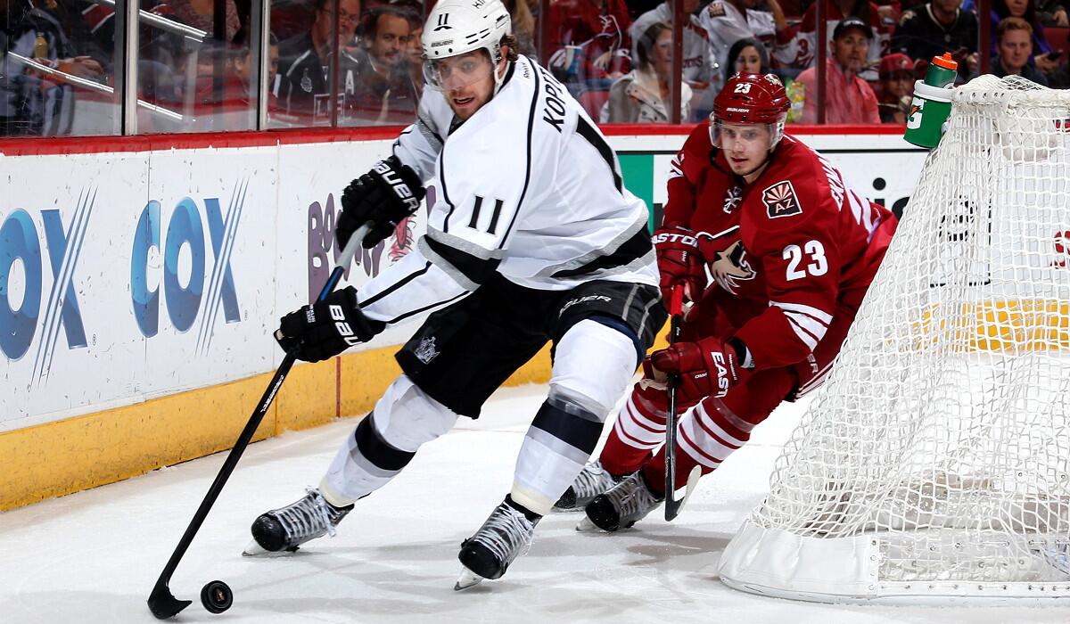 Kings center Anze Kopitar brings the puck around the goal against Coyotes defenseman Oliver Ekman-Larsson during a Dec. 4 game in in Glendale, Ariz.
