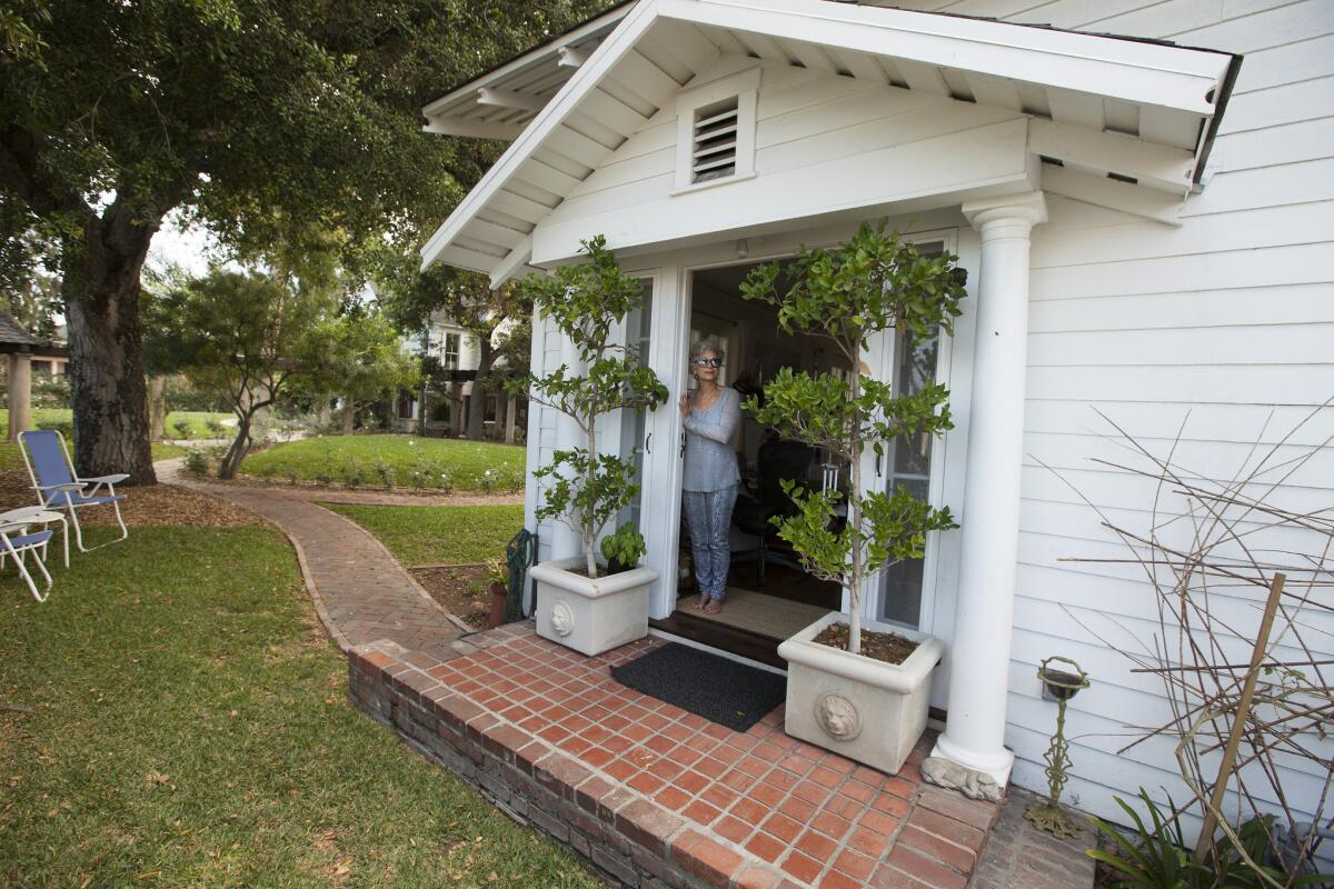 Artist Tamra Fago stands in the front doorway of her 900-square foot home in the Garvanza neighborhood near downtown L.A.