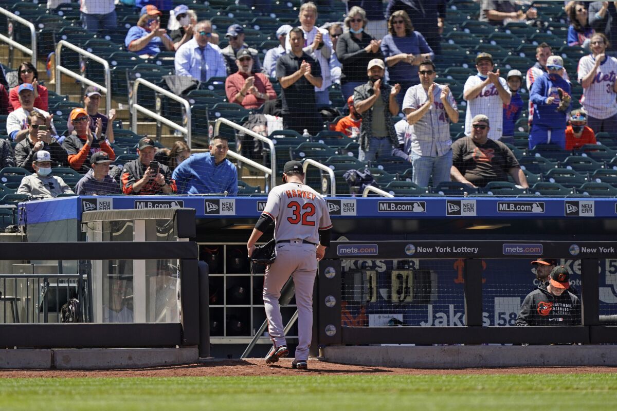 Fans stand and applaud Baltimore Orioles starting pitcher Matt Harvey (32) as he leaves the mound during the fifth inning of a baseball game against his former team, the New York Mets, Wednesday, May 12, 2021, in New York. (AP Photo/Kathy Willens)
