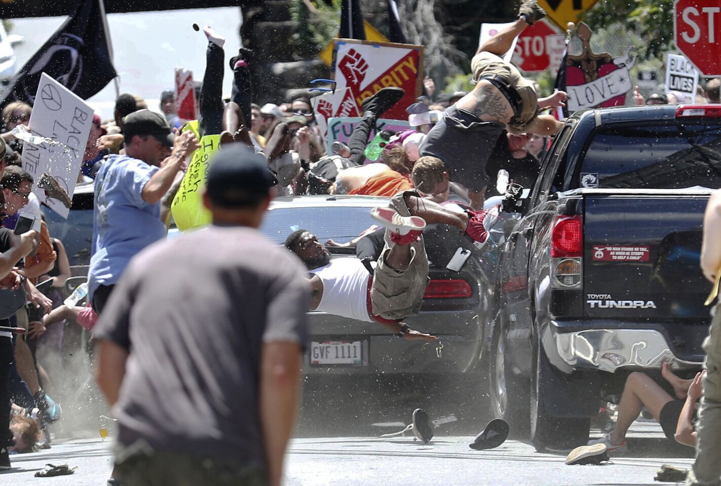 People fly into the air as a vehicle drives into a group of protesters demonstrating against a white nationalist rally in Charlottesville, Va. The nationalists were holding the rally to protest plans by the city of Charlottesville to remove a statue of Confederate Gen. Robert E. Lee.