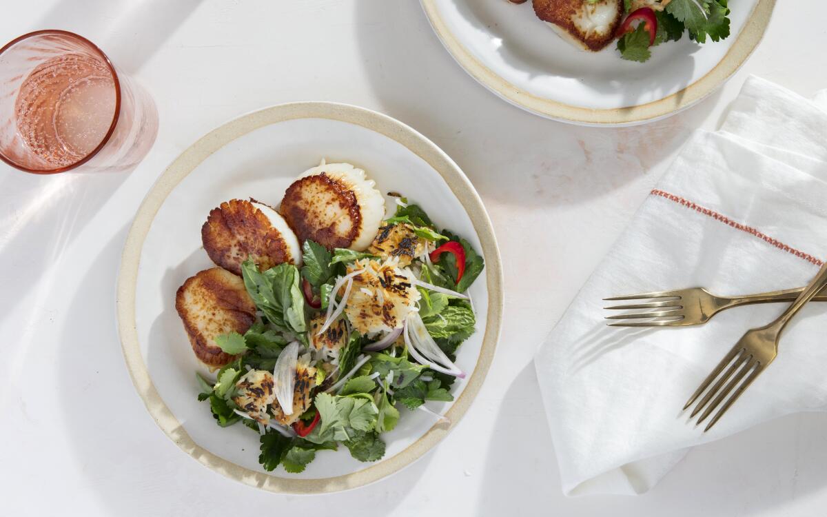 Seared plump scallops with crispy rice and herb salad