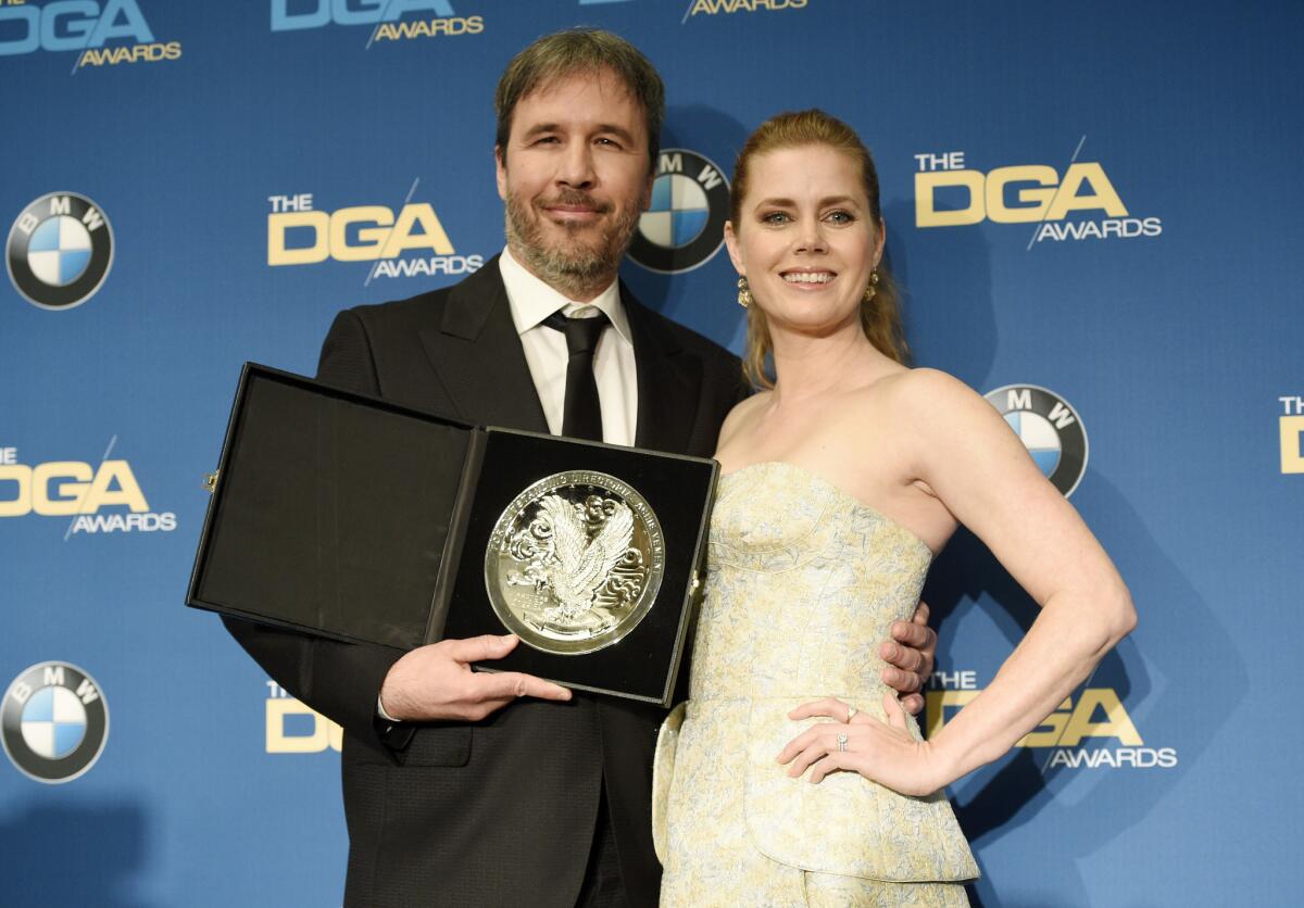 Denis Villeneuve, left, director of "Arrival," holds his nominee's medallion as he poses with the film's star Amy Adams.