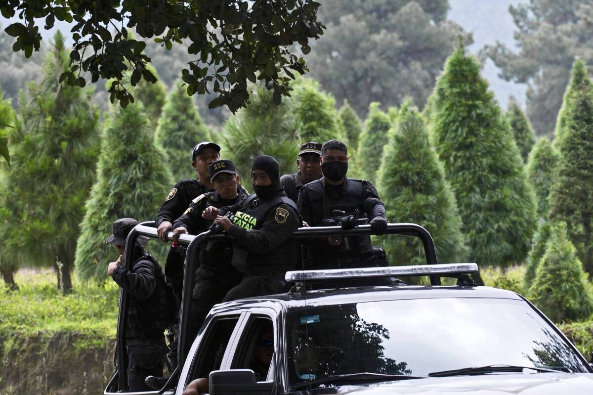 Police officers patrol around the town of Tlalmanalco, where 13 bodies were exhumed from a mass grave on a Christmas tree farm.