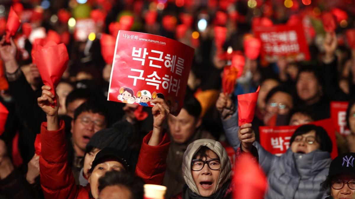 South Koreans shout slogans and hold banners reading "Park Geun-hye Detention" during a March 4 rally against President Park Geun-Hye in Seoul.