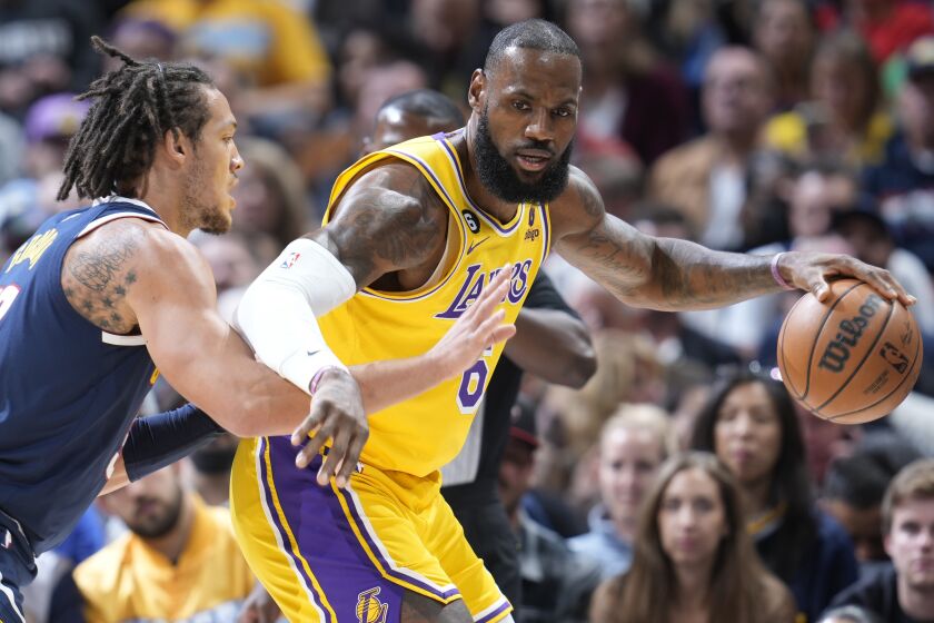 Los Angeles Lakers forward LeBron James, right, looks to pass the ball as Denver Nuggets forward Aaron Gordon.