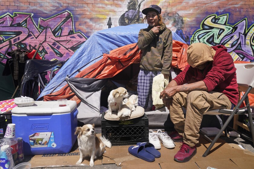 Lucio Lopez, left, talks with friends as he stands in a tent that is part of a homeless encampment in the Queens borough of New York, Tuesday, April 13, 2021. Unemployment among Hispanic immigrants has doubled in the U.S., going from 4.8% in January 2020 to 8.8% in February 2021, according to the Migration Policy Institute. These numbers don’t take into consideration immigration status but activists and social workers in states like New York or California say more vulnerable immigrants, whom often don't qualify for aid, are finding themselves without a home. (AP Photo/Seth Wenig)