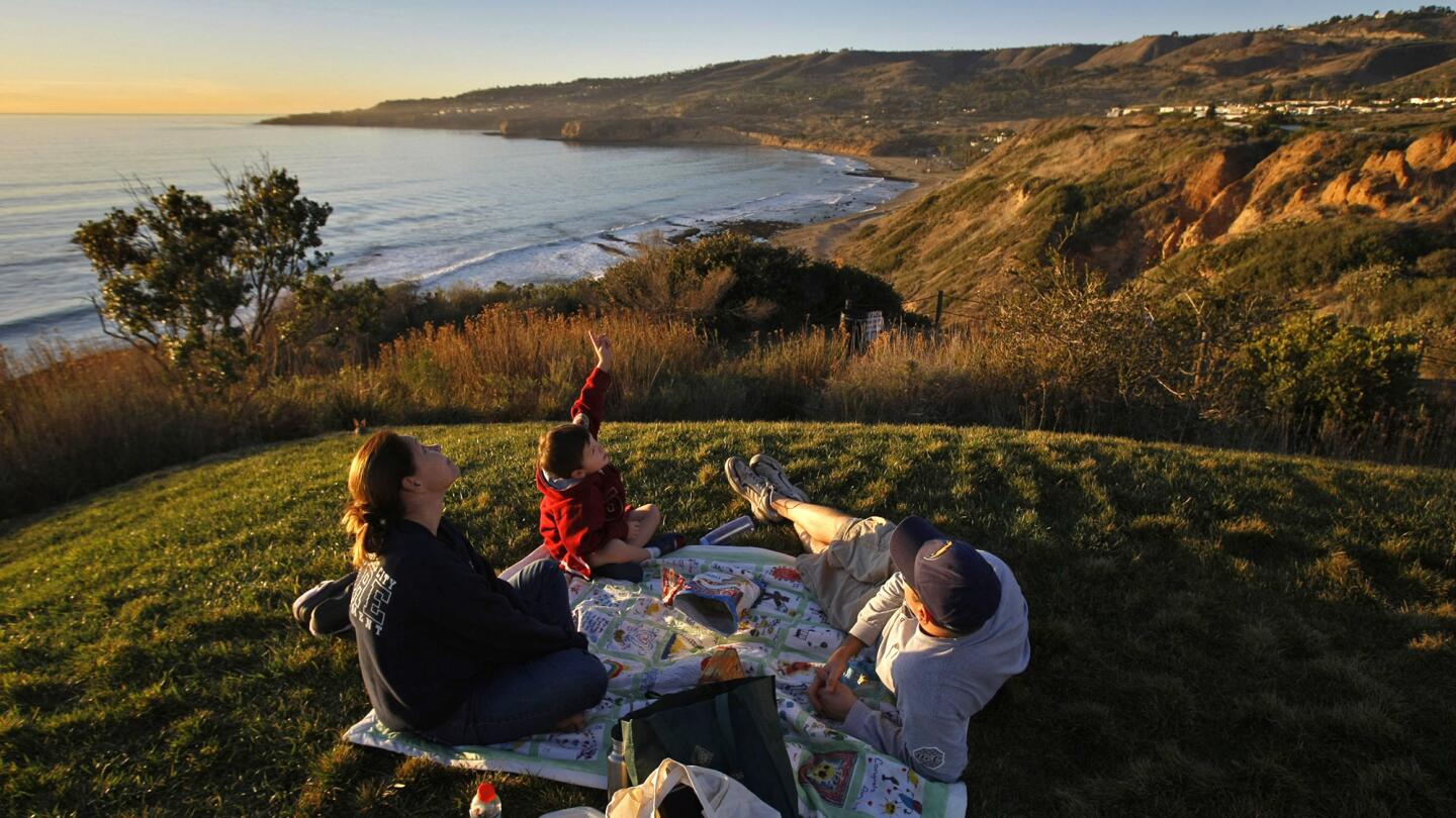 Picnickers enjoy an outing on a bluff overlooking the coastline and Pacific at the Trump National Golf Club.