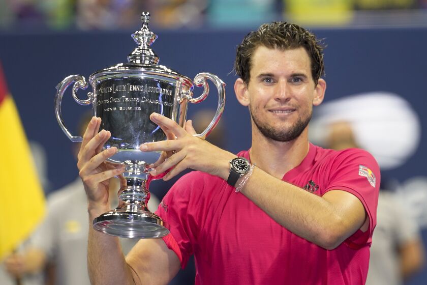 Dominic Thiem, of Austria, holds up the championship trophy after defeating Alexander Zverev.
