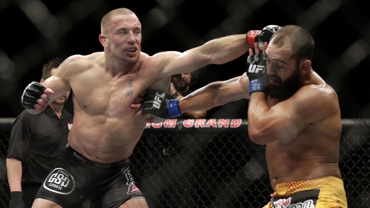 Johny Hendricks, right, exchanges punches with Georges St-Pierre during a UFC 167 in Las Vegas on Nov. 16, 2013. St-Pierre won by split decision.