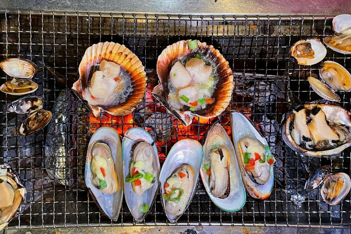 Scallops, clams and mussels on the grill at Jae Bu Do Korean seafood barbecue restaurant