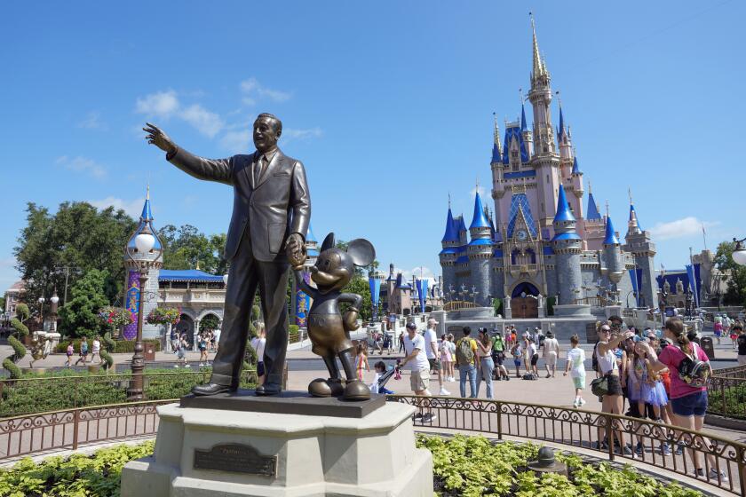 ARCHIVO - Visitantes caminan detrás de la estatua de Walt Disney y Mickey Mouse en el parque de Magic Kingdom, en Walt Disney World, el 14 de julio de 2023, en Lake Buena Vista, Florida. (AP Foto/John Raoux, Archivo)