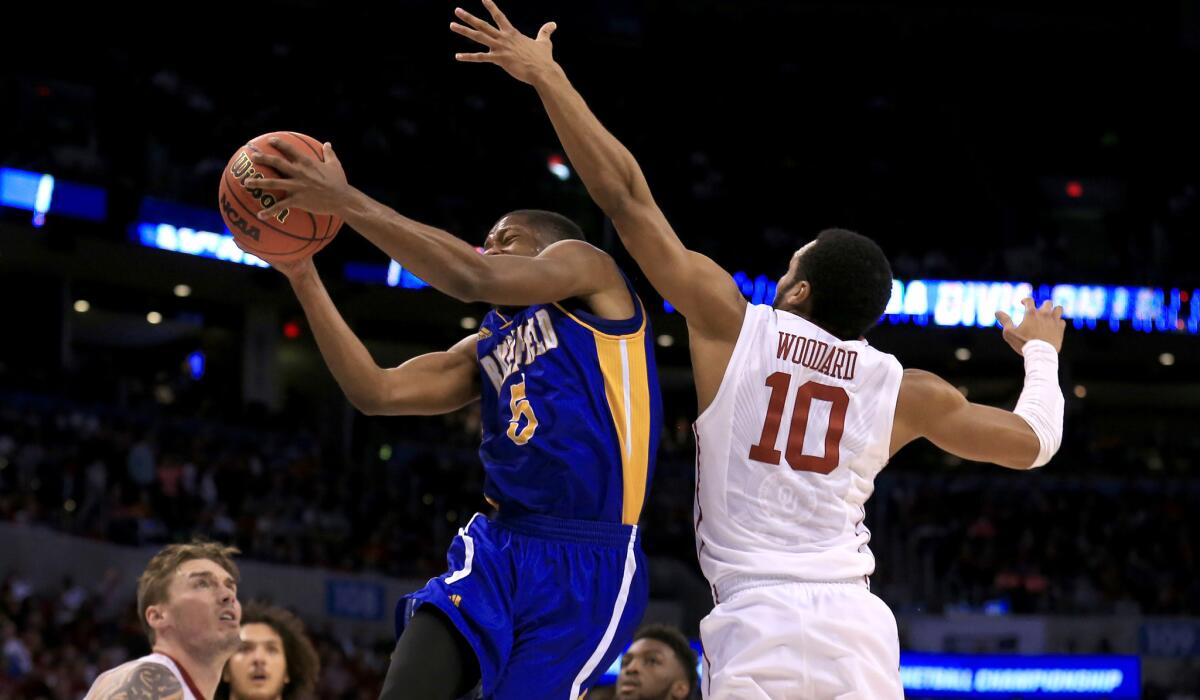 Cal State Bakersfield's Dedrick Basile has his shot challenged by Oklahoma's Jordan Woodard during the second half of Friday's game.