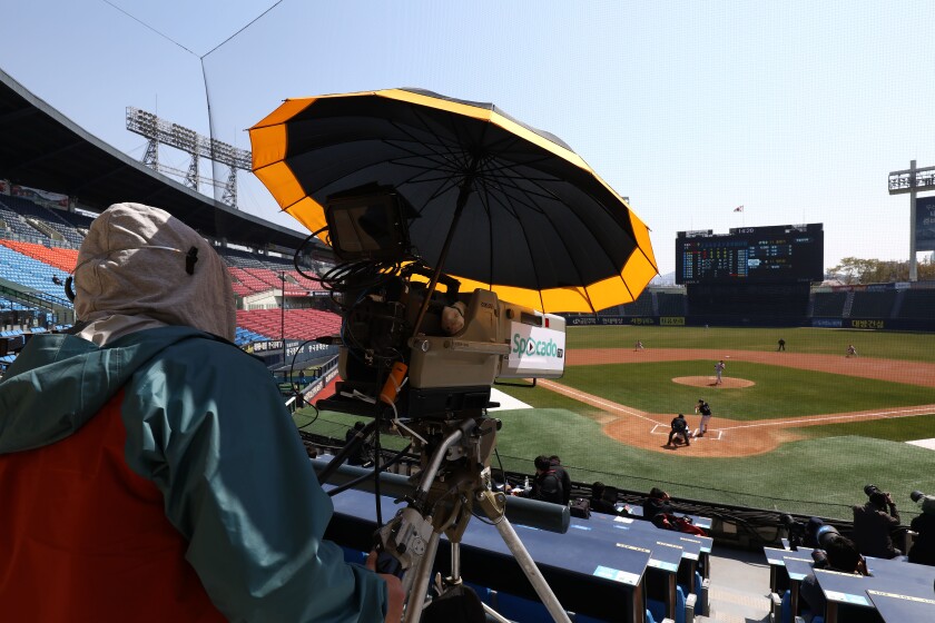 Employees of LG Twins broadcast an intrasquad scrimmage from an empty Jamshil baseball stadium April 5 in Seoul. The Korean Baseball Organization is inching toward an opening day next month.