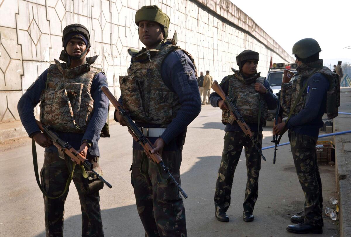 Indian security personnel take positions along a road leading to the air force base in Pathankot.