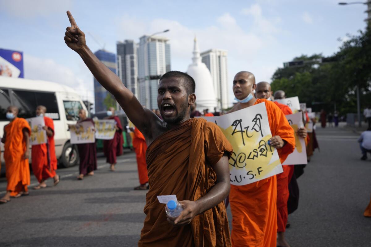 Sri Lankan student Buddhist monks shout slogans as they march demanding President Gotabaya Rajapaksa resign over the economic crisis in Colombo, Sri Lanka, Monday, June 20, 2022. (AP Photo/Eranga Jayawardena)