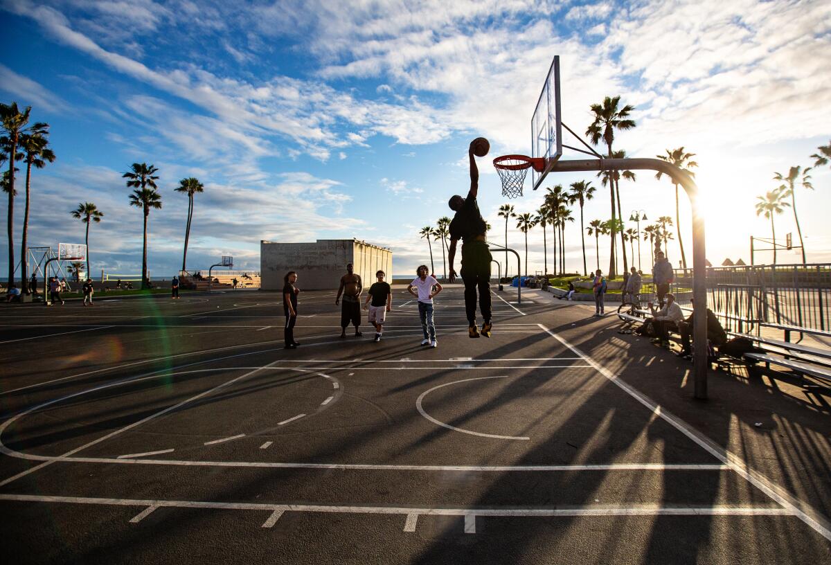 A man dunks on the basketball courts at Venice Beach on Thursday.