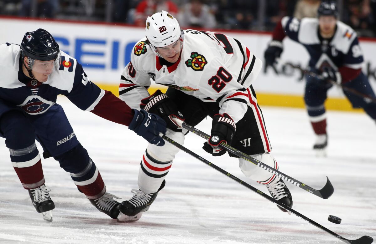 FILE - In this Dec. 21, 2018, file photo, Colorado Avalanche defenseman Tyson Barrie, left, knocks the puck away from Chicago Blackhawks left wing Brandon Saad during the second period of an NHL hockey game in Denver. Saad is part of the new-look Avalanche squad after being acquired in a trade from Chicago. (AP Photo/David Zalubowski, File)