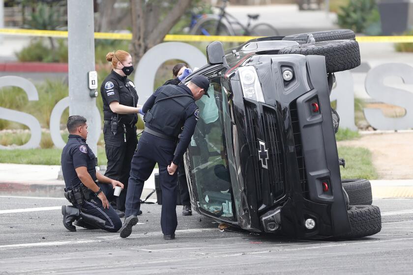 Members of the Costa Mesa PD and crime scene unit process the scene where a street racing incident killed a person at the corner of Hyland and Sunflower in Costa Mesa early Monday morning.