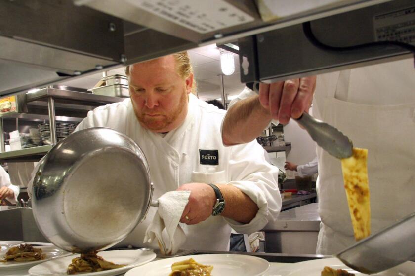 ** FILE ** Chef Mario Batali, center, plates a pasta dish in the kitchen of Del Posto, his Italian restaurant in New York, in this Feb. 8, 2006, file photo. Despite a dispute with its old landlord that led to threats of eviction and a costly legal battle, the restaurant, owned by celebrity chefs Batali and Lidia Bastianich, will remain open. The building has a new owner, and with the purchase, Joseph Bastianich, Lidia's restaurateur son, said Tuesday June, 12, 2007, that the litigation was terminated. (AP Photo/Tina Fineberg, File) ORG XMIT: NYR113