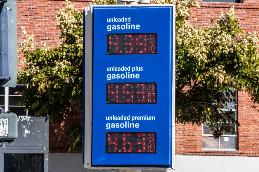 A gas station sign showing its prices.