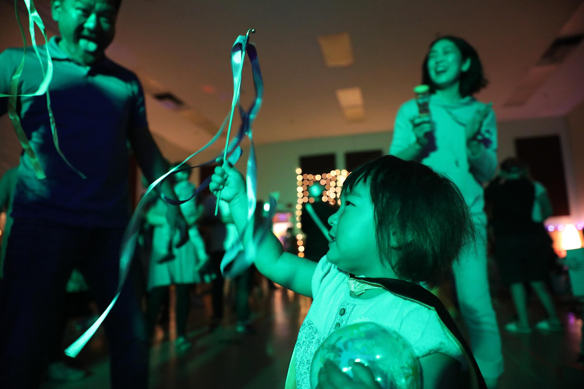 10-month-old Ariel Harenburg, center, soaks up the atmosphere at a recent Baby Rave.