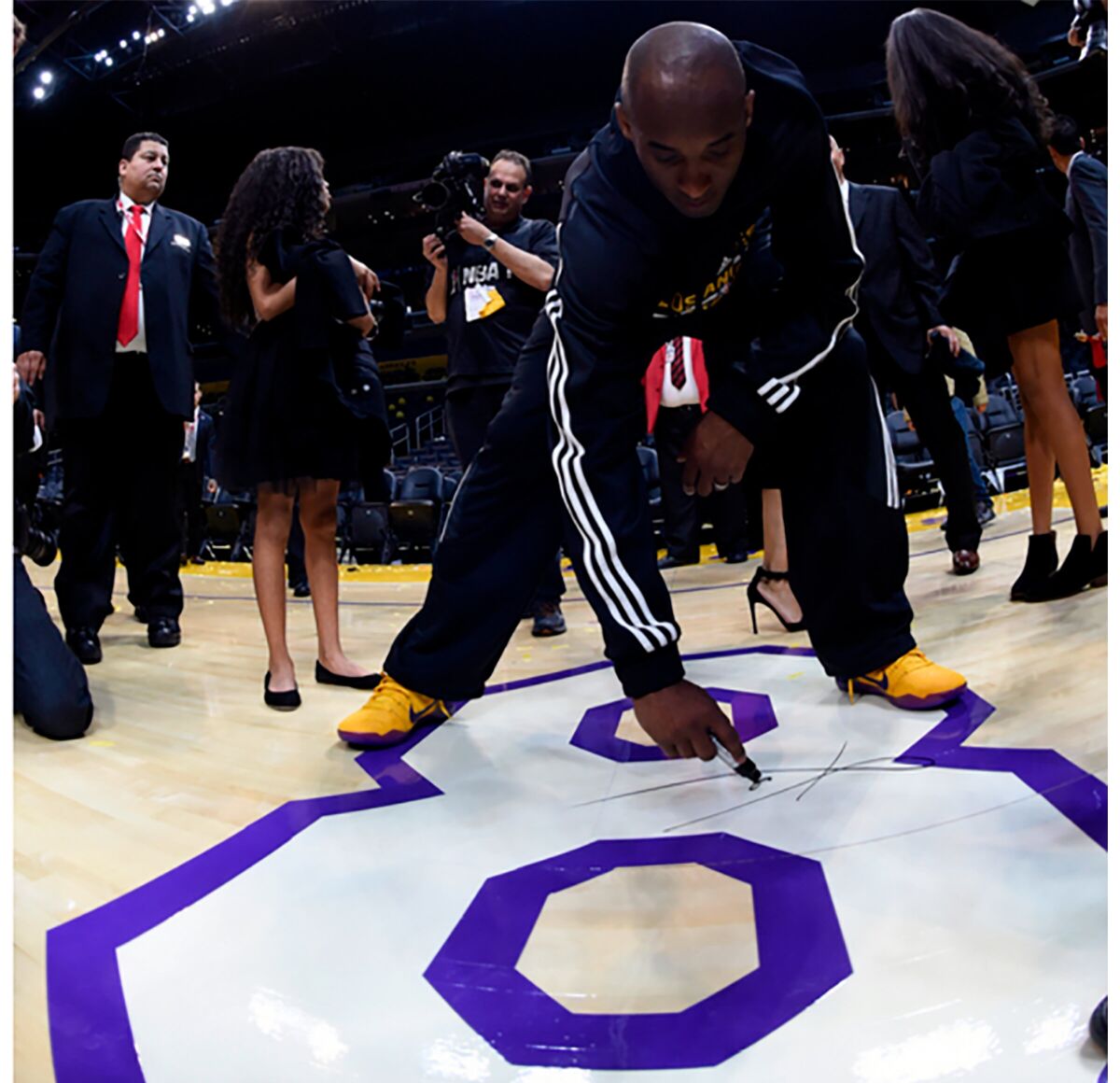 Kobe Bryant signs the No. 8 painted on the Staples Center floor following his final NBA game on April 13, 2016.
