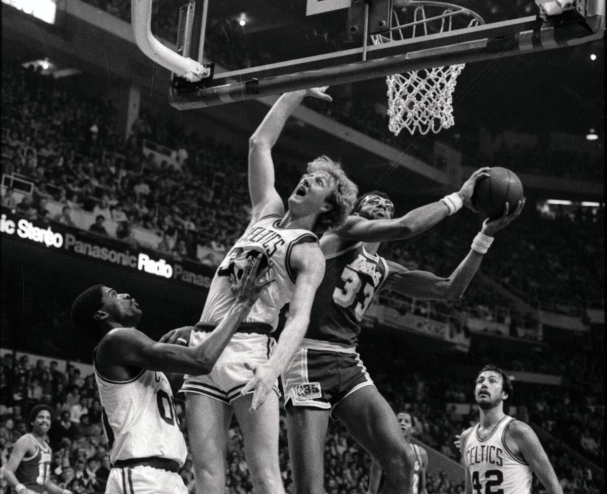 Lakers center Kareem Abdul-Jabbar attempts a layup around Celtics forward Larry Bird on Jan. 18, 1981, at the Boston Garden.