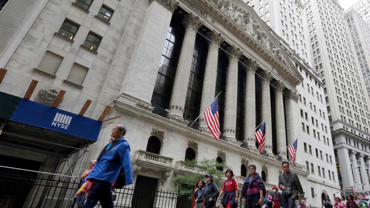 People pass the New York Stock Exchange on Oct. 24, 2017.