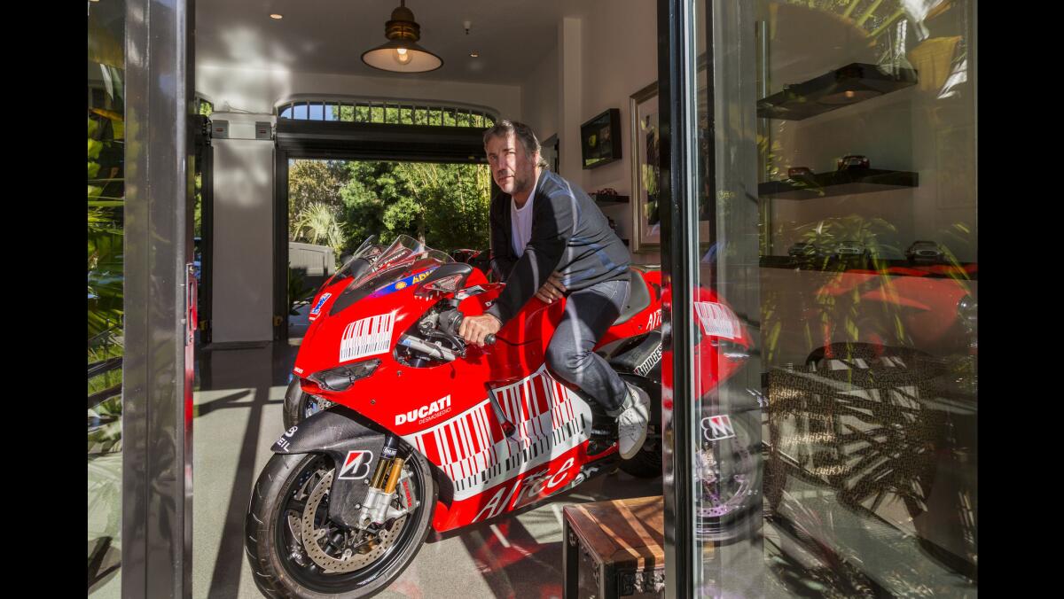 Jerome Dahan poses on one of his Ducati motorcycles in the garage "museum" of his 1913 home in Santa Monica.