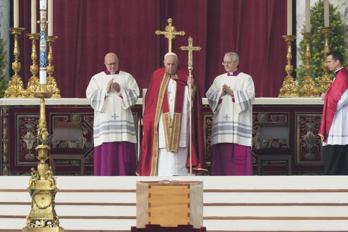 Pope Francis standing before the coffin of Pope Emeritus Benedict XVI