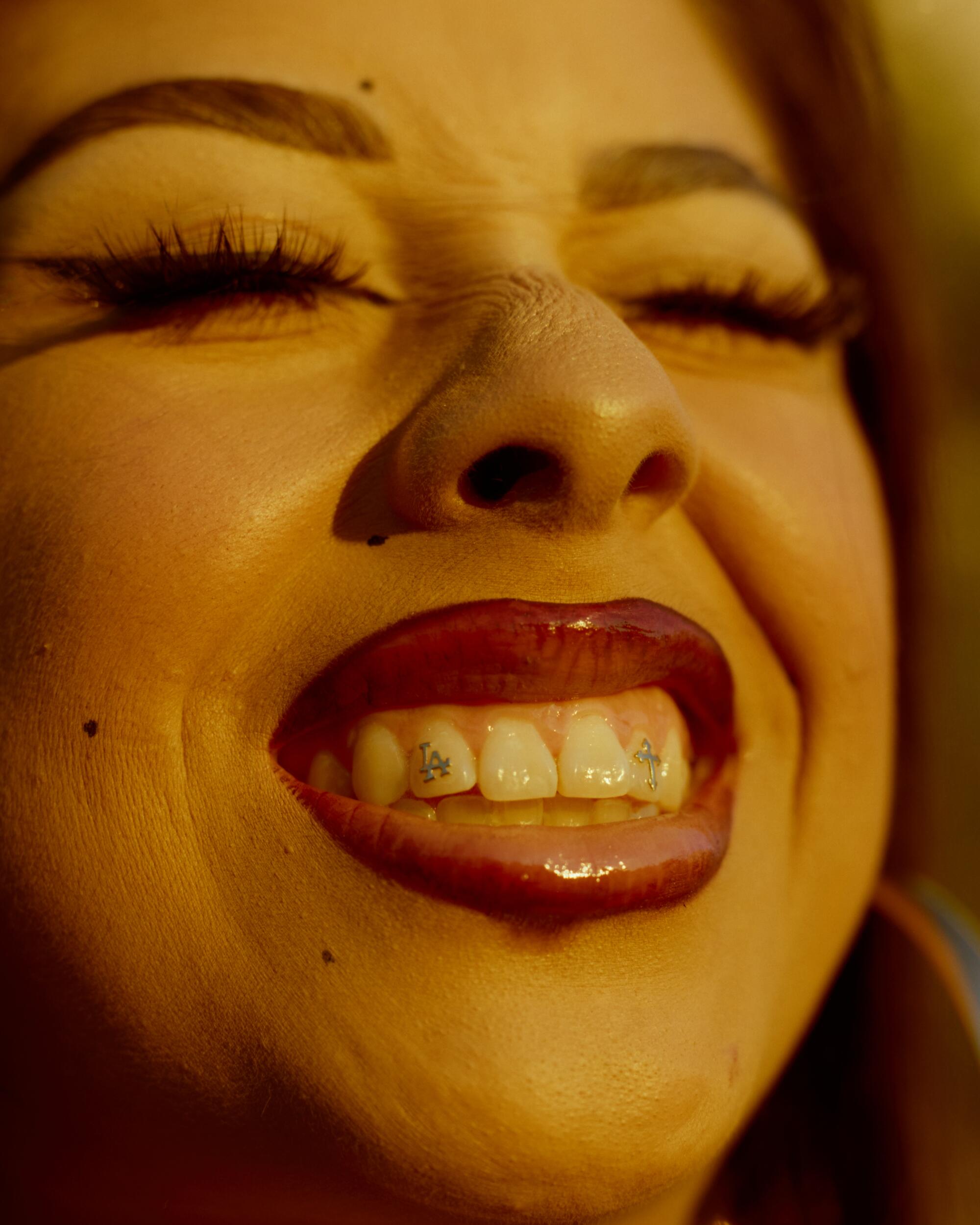Julianna Aguirre Martinez flashes their tooth gems. For some, Homies remain an ode to Chicano beauty.