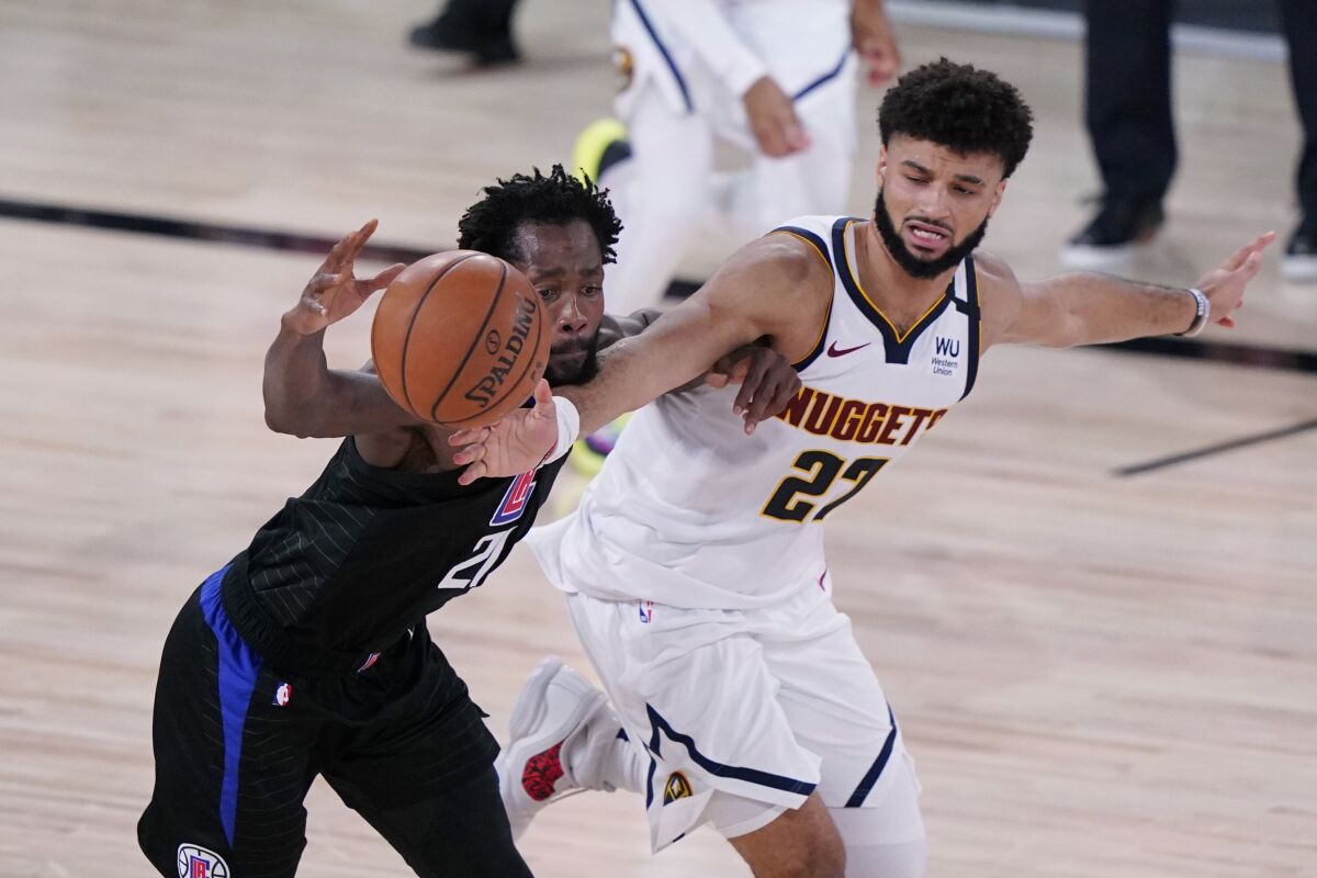 Los Angeles Clippers guard Patrick Beverley (21) is pressured by Denver Nuggets guard Jamal Murray (27) as he drives with the ball during the second half of an NBA conference semifinal playoff basketball game Tuesday, Sept. 15, 2020, in Lake Buena Vista, Fla. (AP Photo/Mark J. Terrill)