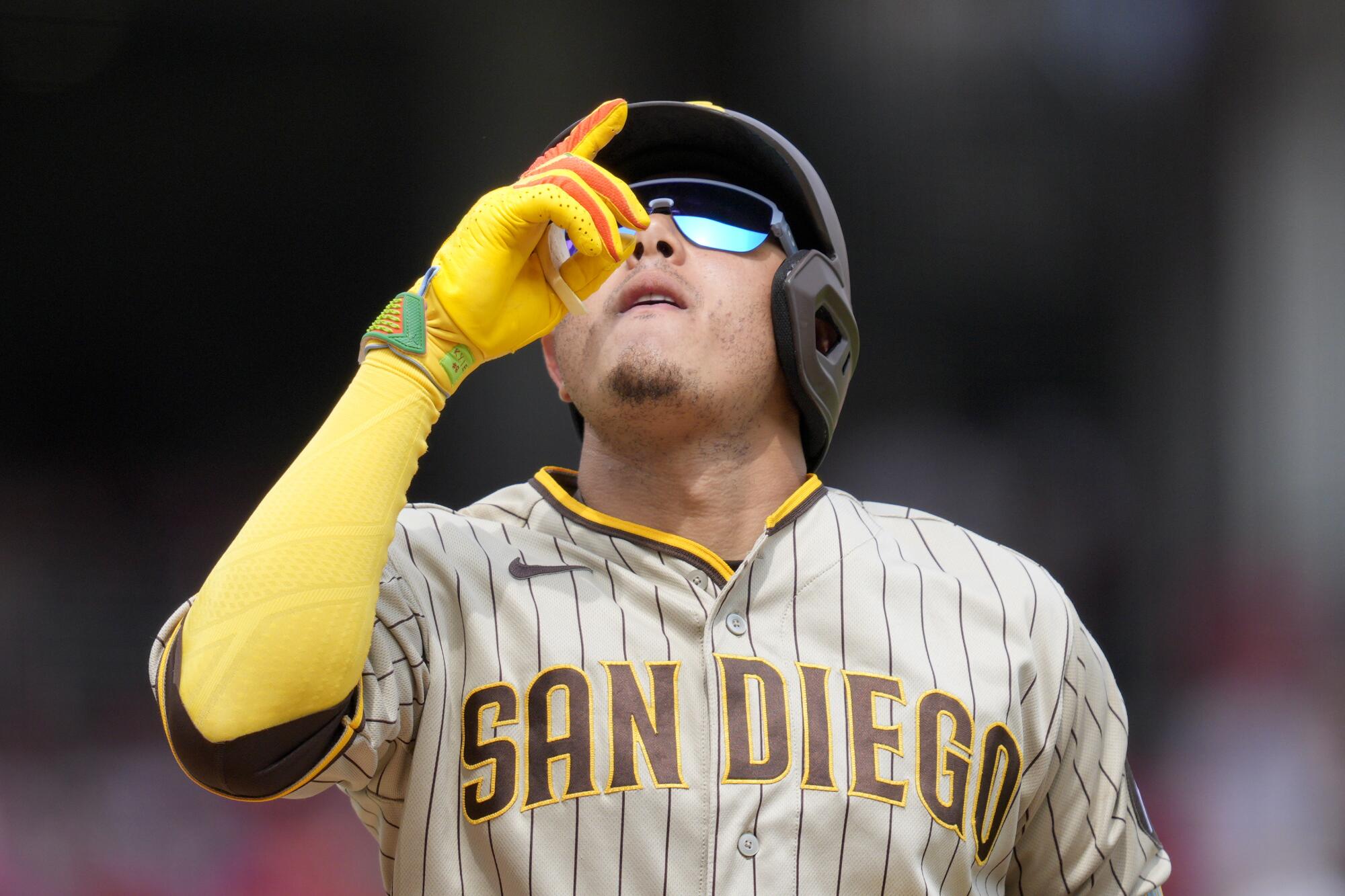 San Diego Padres' Manny Machado, center, talks with Cincinnati