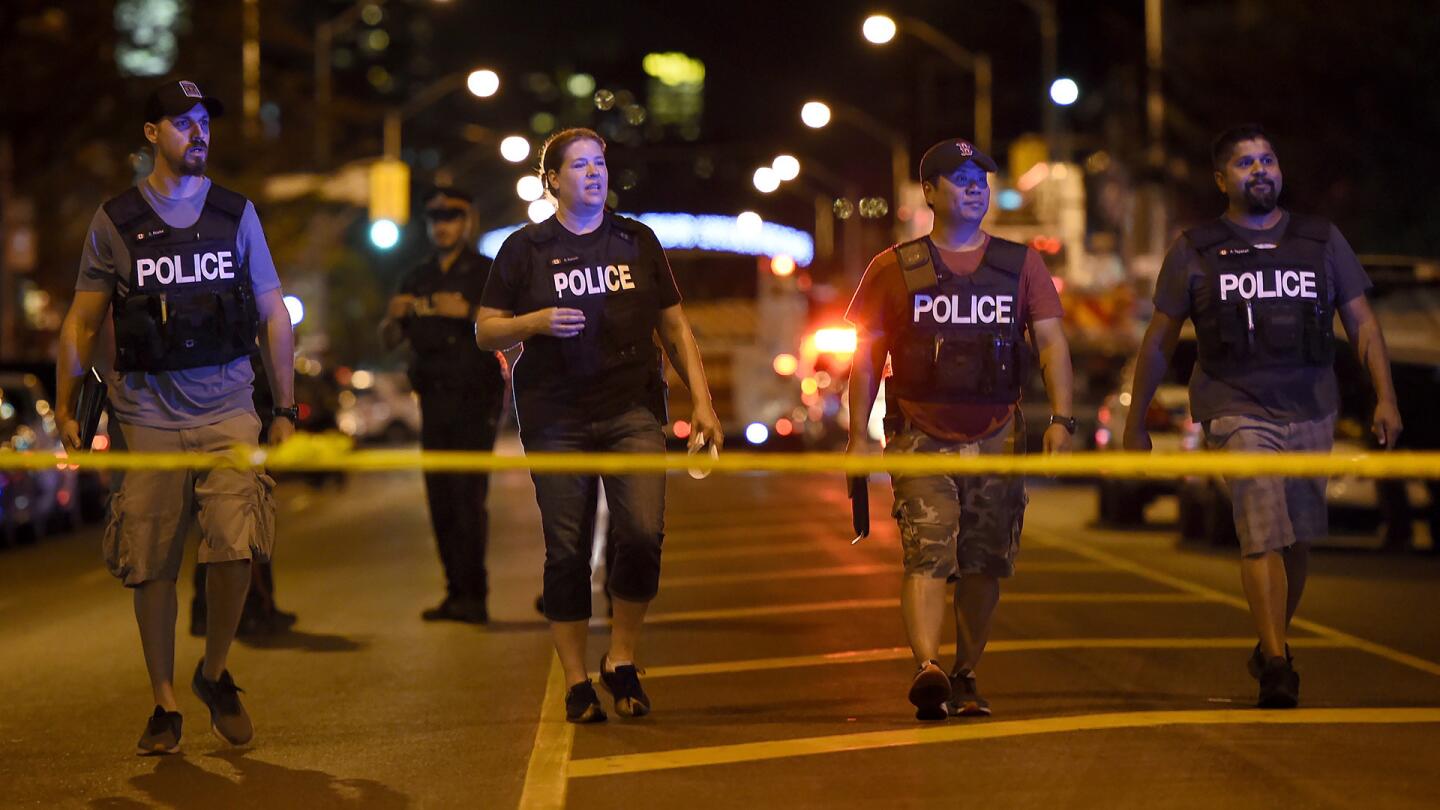 Plainclothes police officers work the scene of a shooting in Toronto on Sunday, July 22, 2018.