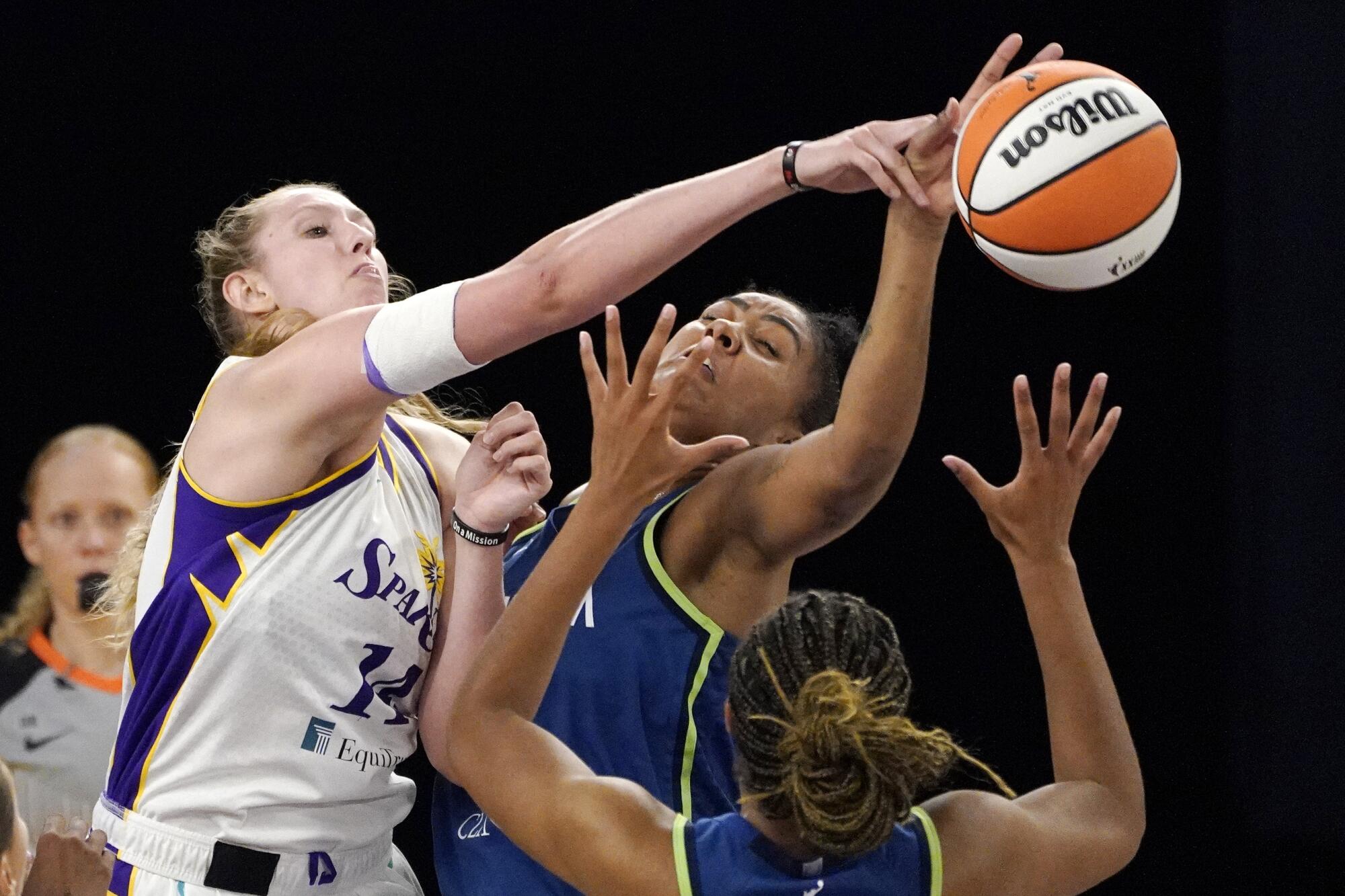 Sparks forward Lauren Cox battles Minnesota forwards Damiris Dantas and Napheesa Collier for a rebound.