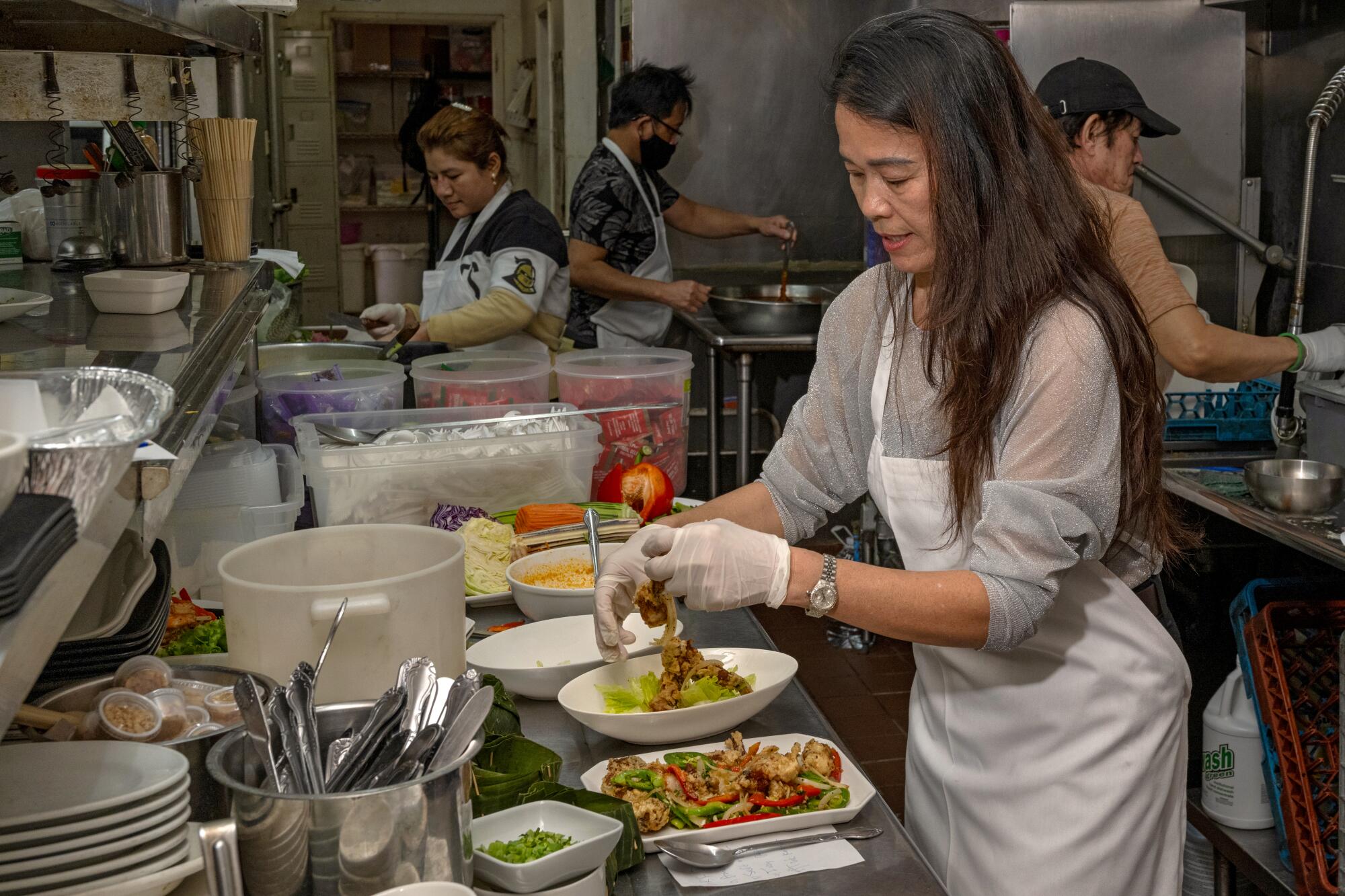 Chef Sophy Khut plates a dish in the kitchen at Sophy's: Cambodia Town Food & Music