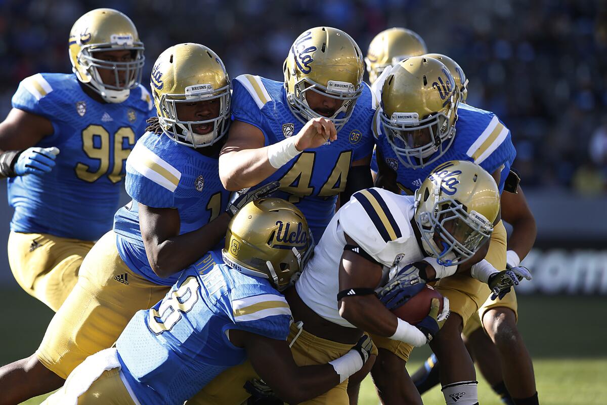 Craig Lee is swarmed by defenders during UCLA's annual spring game at the StubHub Center.