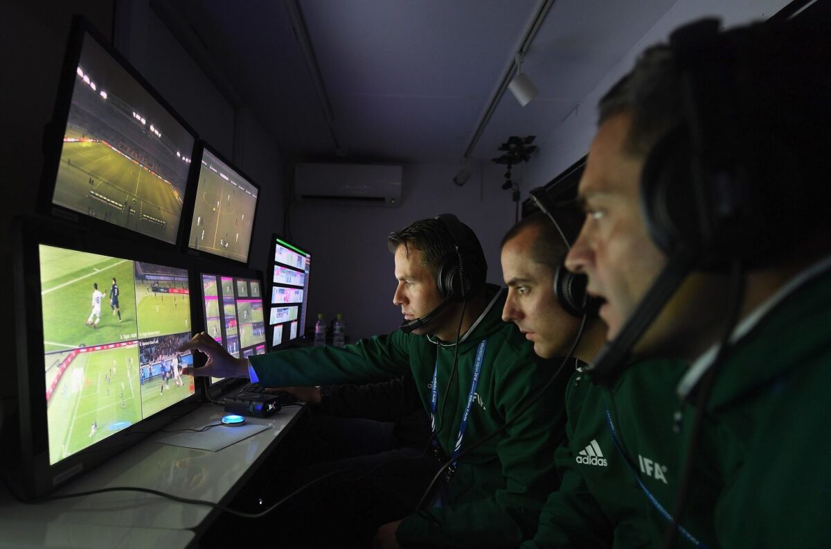 Un árbitro y dos asistentes de vídeo siguen el juego en sus monitores durante el partido del Mundial de Clubes de Japón 2016 entre el Kashima Antlers y el Auckland City en el estadio Yokohama de Japón.