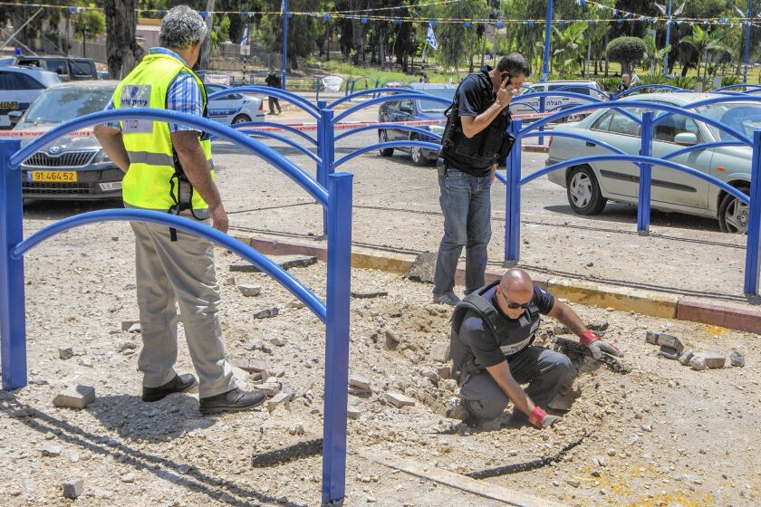 Bomb disposal experts inspect the damage and collect the remains of a rocket fired by Palestinian militants from the Gaza Strip outside a house in the southern Israeli city of Sderot.