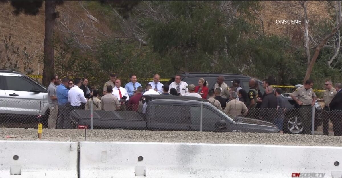Sheriff's homicide investigators huddle Friday morning in Encinitas after fatal shooting of a man by two deputies.
