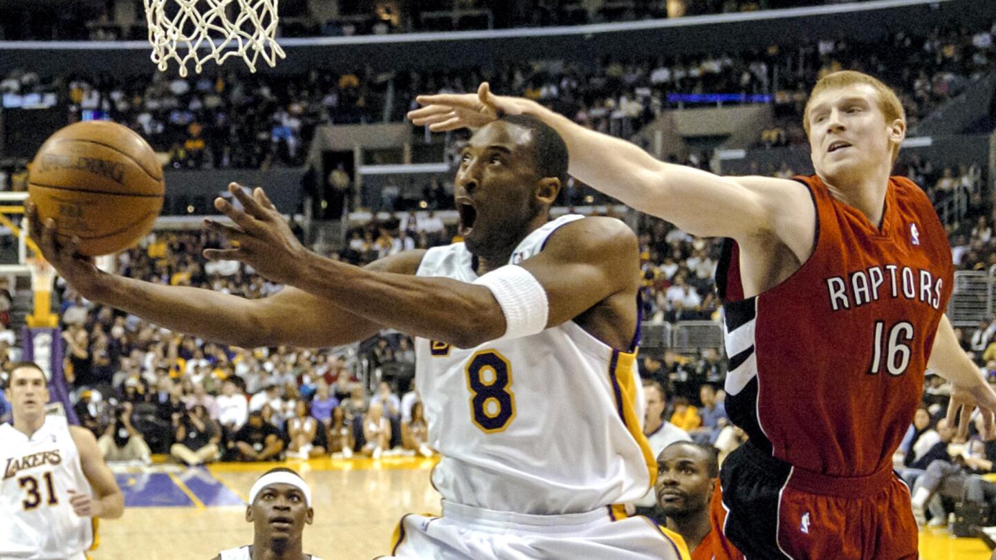 Lakers guard Kobe Bryant gets past Raptors forward Matt Bonner for a reverse layup in the first half.