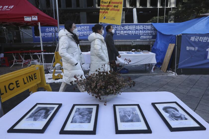 Portraits of late former South Korean comfort women are displayed near the Japanese Embassy in Seoul, South Korea, Friday, Jan. 8, 2021. A South Korean court on Friday ordered Japan to financially compensate 12 South Korean women forced to work as sex slaves for Japanese troops during World War II, the first such ruling expected to rekindle animosities between the Asian neighbors. (AP Photo/Ahn Young-joon)