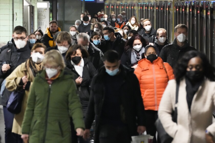Commuters wearing face masks to protect against the coronavirus as they arrives at the public transport station in Berlin.