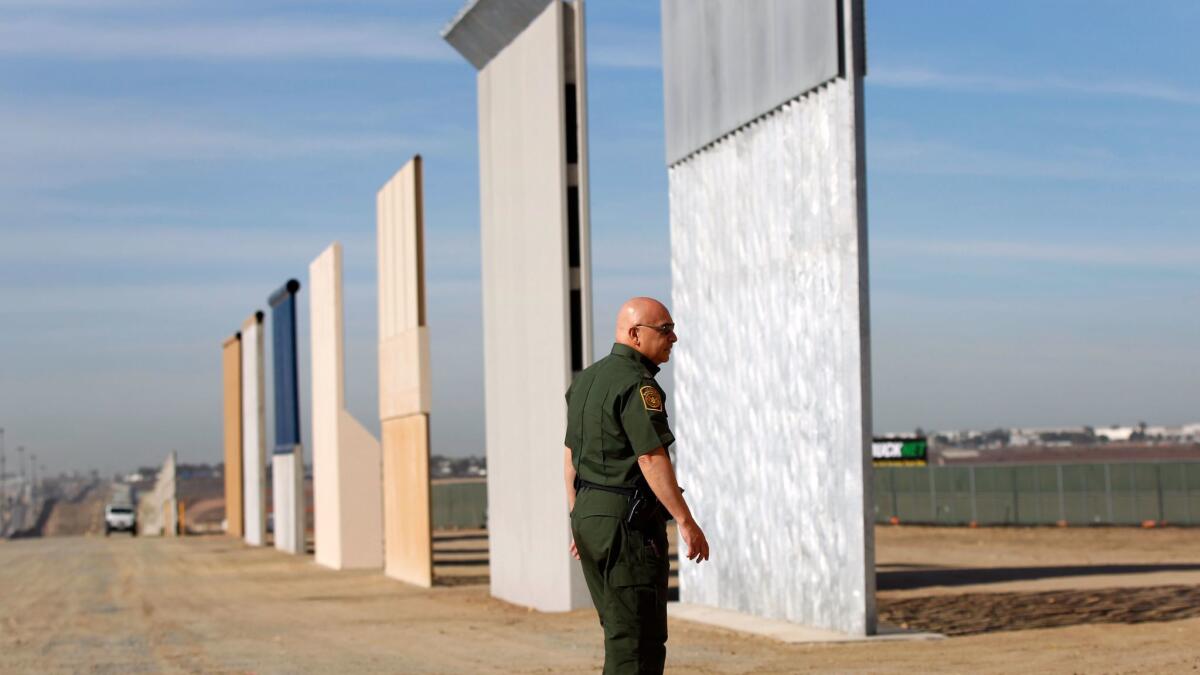 Mario Villarreal, the field office division chief for Customs and Border Protection, walks near the border wall prototypes that were built east of San Ysidro on the border of Mexico, shown here on Monday, Nov. 20, 2017.