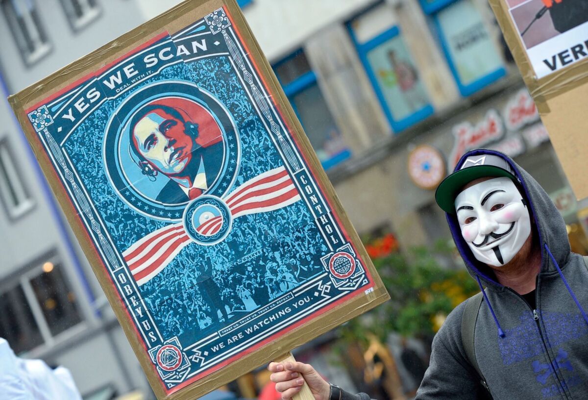 A demonstrator holds a placard with a picture of President Obama at a protest against U.S. intelligence programs in Hanover, Germany.