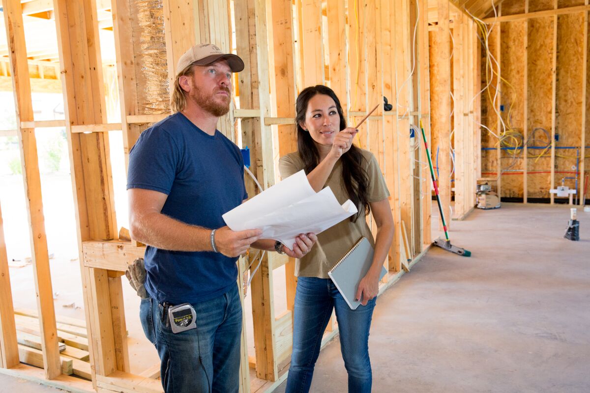 A man and woman stand in a construction site