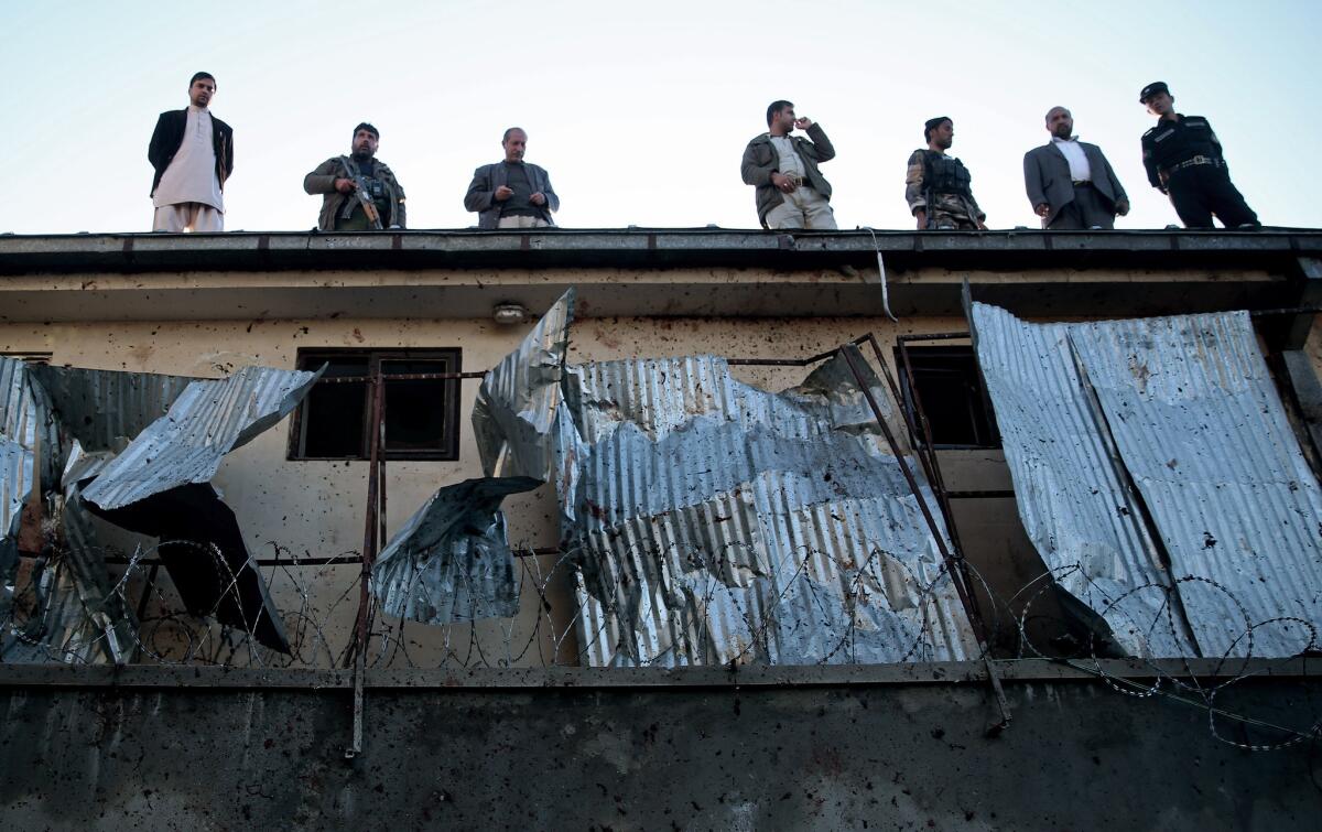 Afghan security forces stand guard on the roof of the Independent Election Commission building after a gun battle between security forces and insurgents in Kabul, Afghanistan.