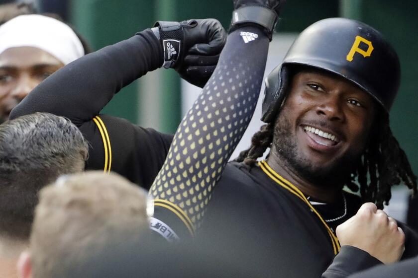 Pittsburgh Pirates' Josh Bell, right, celebrates in the dugout after hitting a solo home run off Colorado Rockies starting pitcher Jon Gray during the second inning of a baseball game in Pittsburgh, Wednesday, May 22, 2019. (AP Photo/Gene J. Puskar)